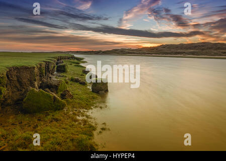 Il fiume ogmore Galles del Sud, al tramonto. una lenta velocità di otturatore ha livellato il fiume e la riva del fiume sembra essere erodendo Foto Stock