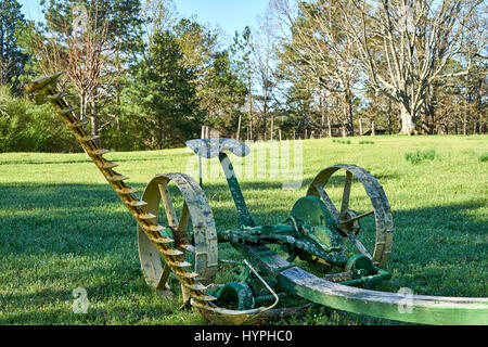 Un cavallo tirato il tosaerba riposa in un campo aperto come un promemoria dei tempi andati. Foto Stock