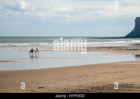 Due donne a cavallo sulla spiaggia di Saltburn, England, Regno Unito Foto Stock