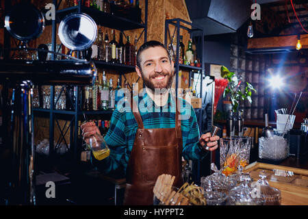 La barista ride facendo un cocktail presso il bar Foto Stock