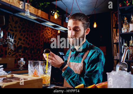 La barista ride facendo un cocktail presso il bar Foto Stock