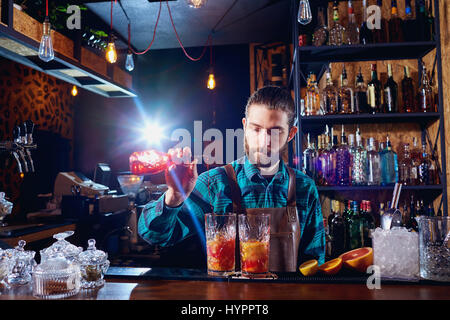 La barista ride facendo un cocktail presso il bar Foto Stock