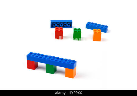 Passi per costruire un ponte o viadotto modello di pezzi di Lego. Blue bridge deck poggiante su tre pilastri colorati. Foto Stock