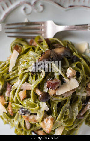 Verde Pasta Spinaci Tagliatelle con pancetta, Marrone funghi shimeji e formaggio parmigiano Foto Stock