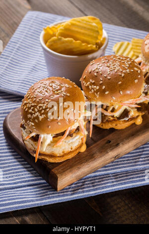 In casa Mini Hamburger di manzo con insalata Coleslaw sul piccolo tagliere di legno. Carne alla Brace panini sul tavolo rustico. Foto Stock