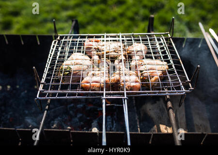 Primo piano di alcuni spiedini di carne alla griglia essendo in un barbecue Foto Stock