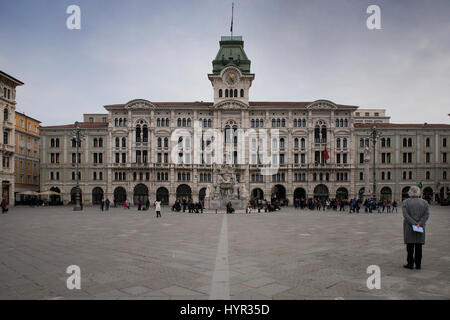 Un turista su Piazza Unità d'Italia, la piazza principale di Trieste, guardando il palazzo comunale. Trieste, Friuli Venezia Giulia, Italia. Foto Stock