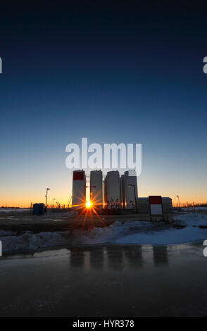 Sun star tra contenitori di gas al tramonto in Canada Foto Stock