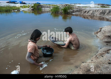 Due minatori panning per oro su un laghetto in Galangan miniera d'oro in Kereng Pangi, Kalimantan, Indonesia. Foto Stock