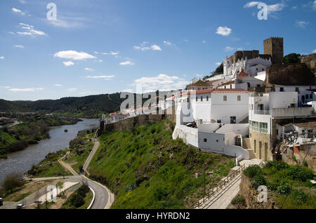 Mertola castello in cima alla collina e la parte più antica della città di fronte al fiume Guadiana lungo il pendio. Alentejo, Portogallo. Foto Stock