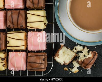 Iced fantasia fondente torte a base di pan di spagna contro uno sfondo nero Foto Stock