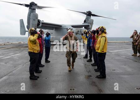 Stati Uniti Marines Comandante Generale Lawrence Nicholson saluta sideboys arcobaleno come egli arriva a bordo della USN San Antonio-classe di trasporto anfibio dock nave USS Green Bay Marzo 21, 2017 nel Mar Cinese Orientale. Foto Stock