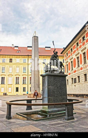 Praga, Repubblica Ceca - 10 Giugno 2012: Obelisco e la statua di San Giorgio al Castello di Praga, Repubblica Ceca. Persone sullo sfondo. Foto Stock