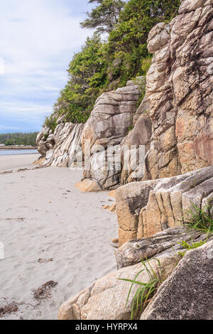 Erose scogliere di granito luogo accanto ad una spiaggia di sabbia sull'esterno esposto costa di Calvert Isola, British Columbia. Foto Stock