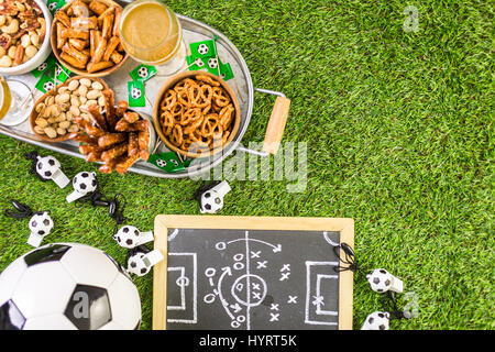 Snack salati e bevande sul vassoio di metallo per il calcio partito. Foto Stock