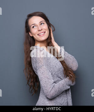 Ritratto di profilo di un attraente giovane donna sorridente con le mani nei capelli Foto Stock