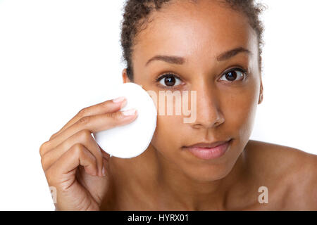 Close up ritratto di un attraente americano africano donna rimuovere il trucco con spugna Foto Stock