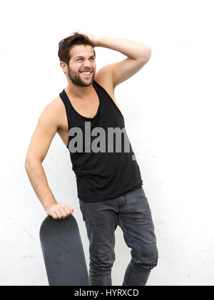 Ritratto di un funky guy holding skateboard contro uno sfondo bianco Foto Stock