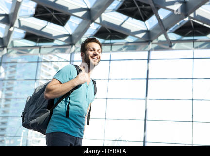 Close up ritratto di un uomo felice in viaggio con sacchetto in aeroporto Foto Stock