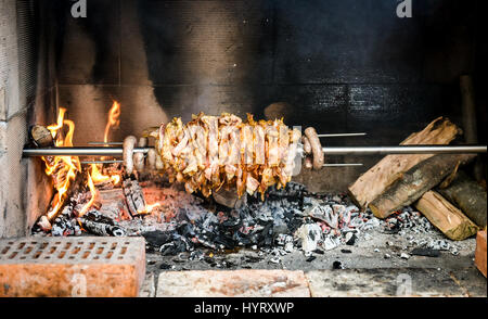 Rendendo fatta in casa cag kebab gyros con il fuoco e carbone. Cağ o kebabı döner è pezzi di carne su un grande spiedo e grigliate in un Barbecue Camino e tagliare wit Foto Stock