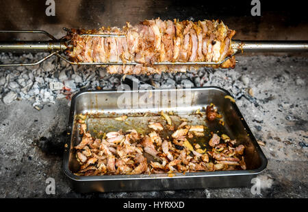 Rendendo fatta in casa cag kebab gyros con il fuoco e carbone. Cağ o kebabı döner è pezzi di carne su un grande spiedo e grigliate in un Barbecue Camino e tagliare wit Foto Stock