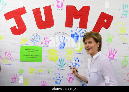 SNP leader e primo ministro Nicola segni di storione suo handprint su una parete di handprints su una campagna visita ad una per bambini club ginnici in Ryton Foto Stock