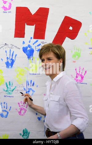 SNP leader e primo ministro Nicola segni di storione suo handprint su una parete di handprints su una campagna visita ad una per bambini club ginnici in Ryton Foto Stock