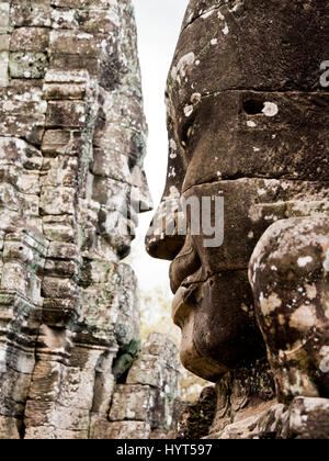 Chiudere verticale dei volti sorridenti del tempio Bayon in Cambogia. Foto Stock