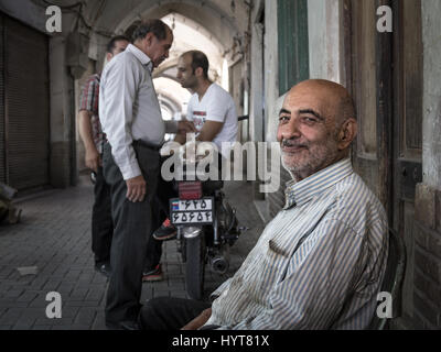 KASHAN, IRAN - Agosto 13, 2016: Vecchio uovo iraniano venditore sorridendo dopo una chiusura trattativa con i compagni di popolo iraniano in background in Kashan Bazaar Baz Foto Stock