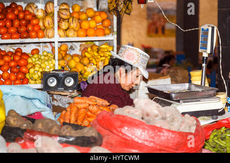 Donna locale stallholder nel tradizionale ricamato rosa hat con rosetta, Chivay, Colca Valley, capitale della provincia di Caylloma, regione di Arequipa, Perù Foto Stock