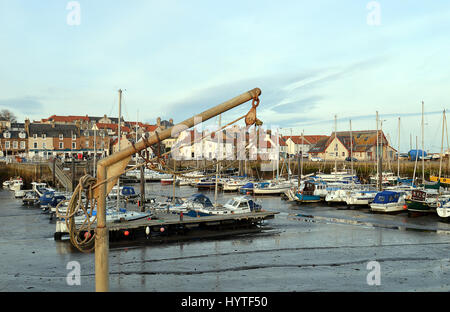 Un vecchio argano di sollevamento sta di fronte al pittoresco porto di Anstruther, Fife, Scozia Foto Stock