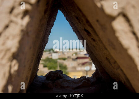 Vista di Khiva città vecchia attraverso la parete della città foro, Uzbekistan Foto Stock