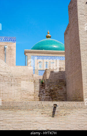 Cupola blu di madrassa dietro la parete, Khiva, Uzbekistan Foto Stock