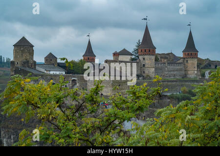 Veduta del castello di kamianets-podilskyi in Ucraina occidentale presi in una piovosa giornata d'autunno. Alberi telaio la parte inferiore dell'immagine Foto Stock