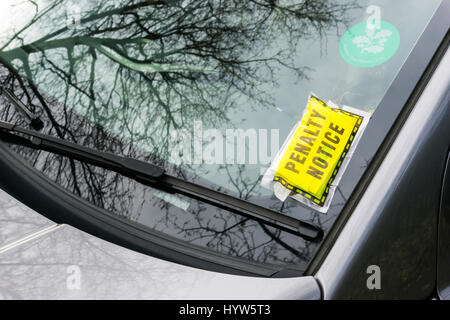 Un parcheggio ticket nota penalità bloccati su un auto del parabrezza. Foto Stock