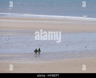 Croyde Beach, Devon, Regno Unito. Il 26 aprile 2017. Surfers camminando giù al mare in una giornata di sole in spiaggia Croyde. Credito: DTNews/Alamy Live News Foto Stock