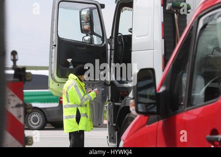 Schleiz, Germania. 26 apr, 2017. Un funzionario di polizia controlla un rimorchio in corrispondenza di una zona di riposo del Autobahn 9 vicino a Schleiz, Germania, 26 aprile 2017. Autovetture e autocarri sono stati controllati come parte di una grande operazione di controllo condotte dalla polizia, dogana, l'Ufficio per la sicurezza sul lavoro e l'Ufficio Ambiente. Foto: Bodo Schackow/dpa-Zentralbild/dpa/Alamy Live News Foto Stock