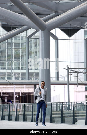 A piena lunghezza Ritratto di un africano uomo a camminare da solo all'aeroporto Foto Stock