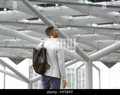 Ritratto da dietro di un uomo nero in piedi da solo in aeroporto con sacco Foto Stock