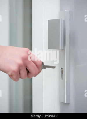 Stretta di mano femminile di sblocco serratura della porta Foto Stock