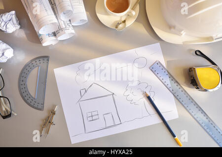 Tavolo di lavoro di un tecnico delle costruzioni con casa concettuale disegno. Blueprint e strumenti dello sfondo. Vista dall'alto. Composizione orizzontale. Foto Stock