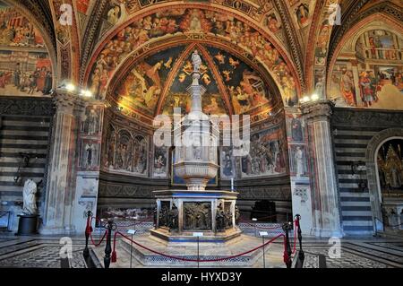 Font nel Battistero di Siena, con tabernacolo marmoreo e la statua di Jacopo della Quercia, pannello di Ghiberti e la fede di Donatello Foto Stock