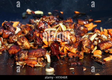 Hot cucinare la carne cipolla carota vegetale in fumo fry sul calderone pan. Gli ingredienti per il pilaf Foto Stock