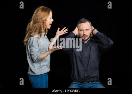 Coppia giovane quarreling isolato su nero Foto Stock