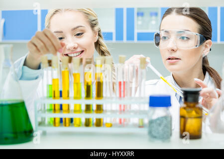 Due donne gli scienziati che lavorano con reagenti in tubi di test in laboratorio Foto Stock