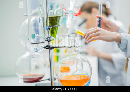 Close-up vista parziale delle donne scienziato che lavora con reagenti di laboratorio chimico Foto Stock