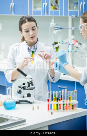 Due donne gli scienziati che lavorano con reagenti di laboratorio chimico Foto Stock