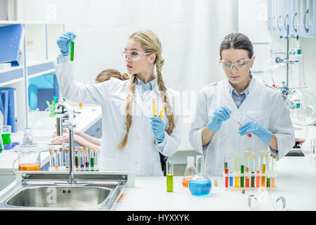 Giovani femmine gli scienziati che lavorano con reagenti di laboratorio chimico Foto Stock