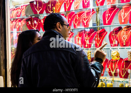 Gli amanti dello shopping sondaggio articoli di gioielleria in oro a metalli preziosi souk, o negozio, nella Medina di Tunisi, Tunisia. Foto Stock