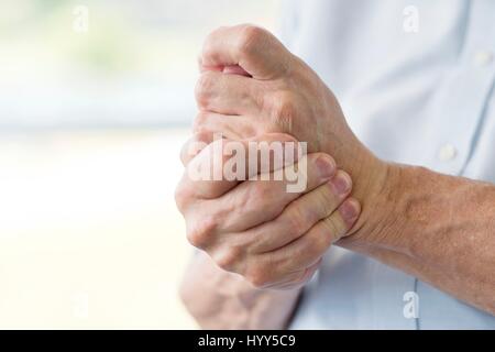 Senior azienda man mano dolorose, vicino. Foto Stock